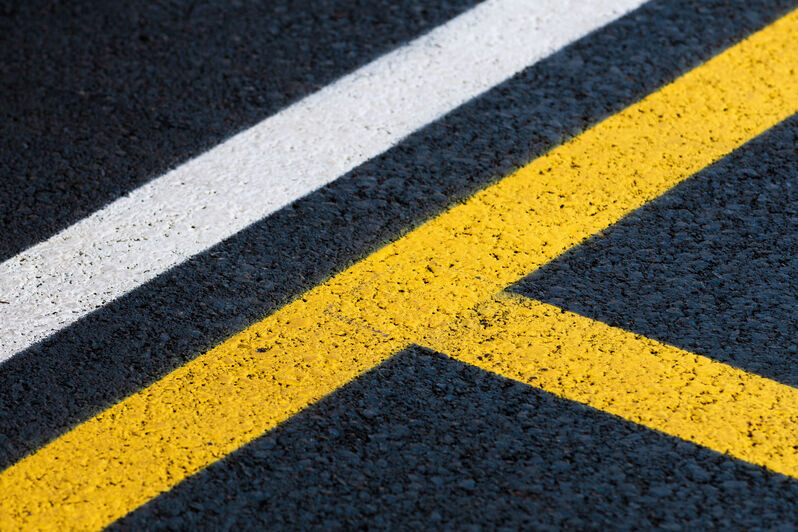 yellow and white lines painted on black asphalt